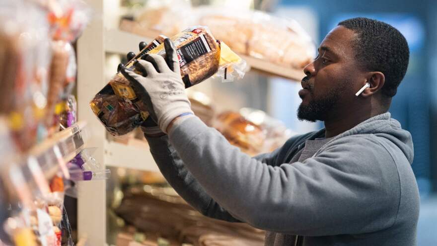 A grocery store worker stocks bread at a MOM's Organic Market in Washington, D.C., on April 2. Last week, bread sales jumped 30% compared to a year ago. But yeast sales were up more than 450%.