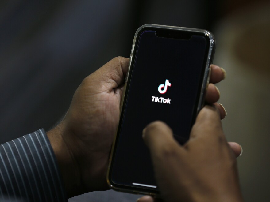 FILE - In this July 21, 2020 file photo, a man opens social media app 'TikTok' on his cell phone, in Islamabad, Pakistan. The owner of TikTok has chosen Oracle over Microsoft as the American tech partner that could help keep the popular video-sharing app running in the U.S., according to a source familiar with the deal who was not authorized to speak publicly about it. (AP Photo/Anjum Naveed, File)