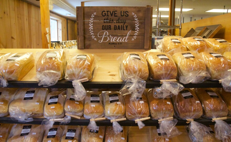 A bread rack with a sign reading give us this day our daily bread