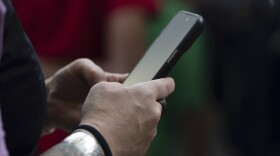 Someone's hand holds a phone.