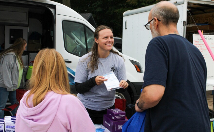 Kianna McConnell offers vistors an opioid overdose response kit during the national Save a Life Day event held at Island Park, Mount Pleasant, Michigan on Thursday, September 25, 2025.