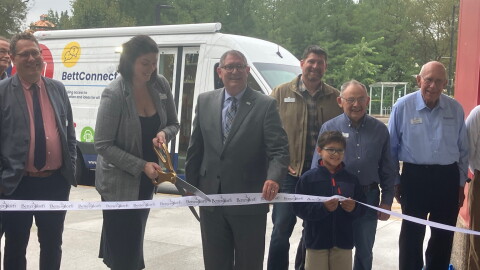 Bettendorf Public Library Director Jillian Aschliman cuts the ribbon (with Mayor Bob Gallagher) on the library's new outreach vehicle, Wednesday, Sept. 30, 2026.