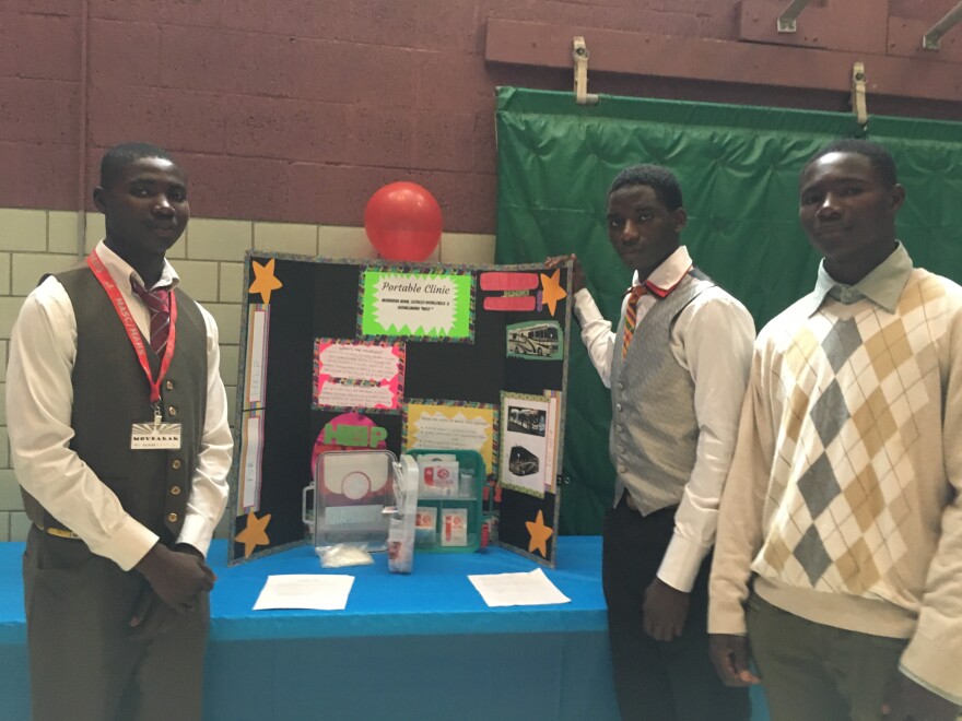 three young men in front of poster board