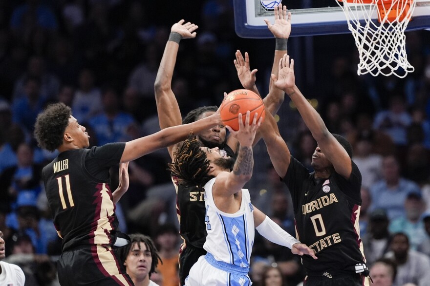 Florida State forward Baba Miller, forward Jaylan Gainey, and guard Chandler Jackson combine to block a shot by North Carolina guard RJ Davis during the second half of an NCAA college basketball game in the quarterfinal round of the Atlantic Coast Conference tournament on March 14, 2024, in Washington. 