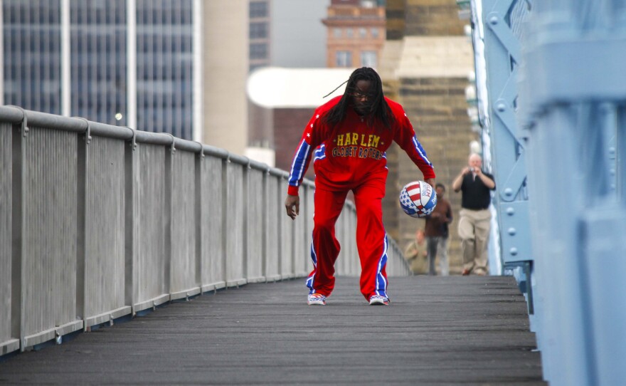 Harlem Globetrotter, Slick Willie Shaw makes his way dribbling down John A. Roebling Bridge.