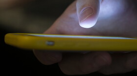 FILE - In this Aug. 11, 2019, file photo, a man uses a cell phone in New Orleans. The U.S. communications regulator on Tuesday, June 9, 2020, proposed a $225 million fine, its largest ever, against two health insurance telemarketers for spamming people with 1 billion robocalls using fake phone numbers.