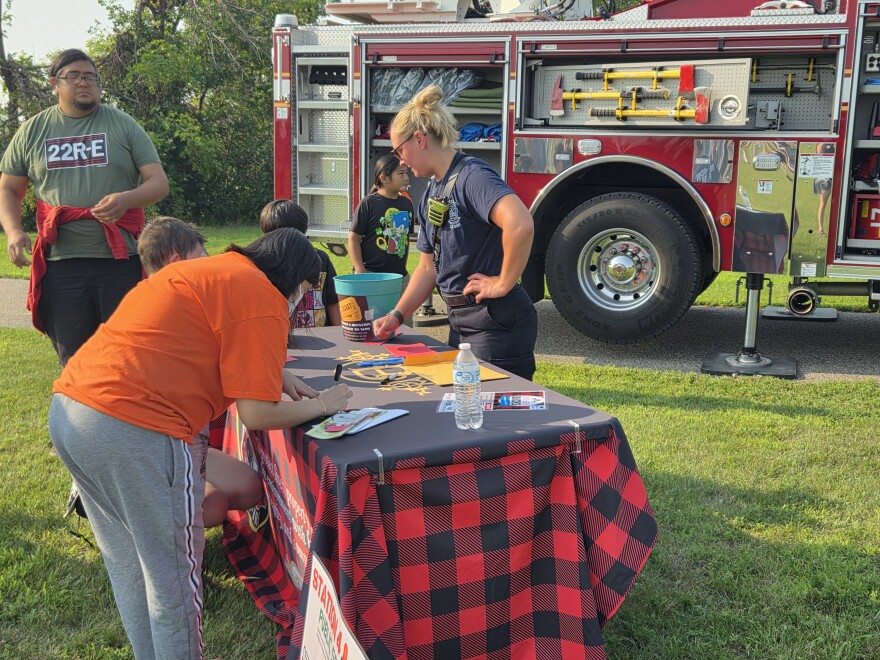 Alexis Joyce, Bemidji firefighter, greets visitors at the Bemidji Fire booth during the Nymore community picnic on July 29, 2025.