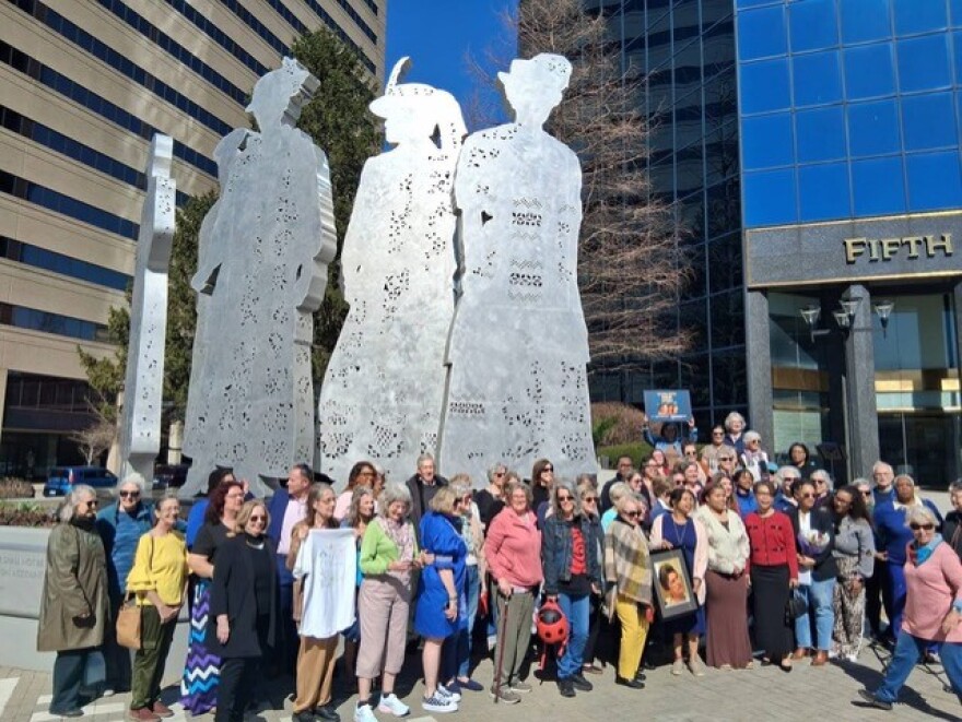 Lexington women gather in front of the city's downtown STAND monument, which honors the women’s suffrage movement.