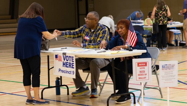 Saginaw Township poll workers Vincent McMillon and May Wathen help a voter prepare to cast her ballot in the August 4 primary election.
