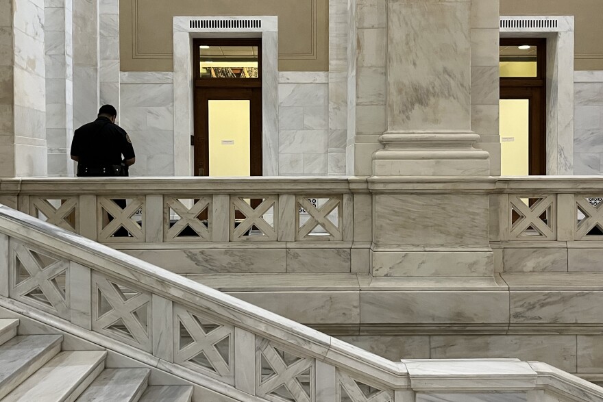 An Arkansas State Capitol police officer stands outside the room Thursday evening where members of the Senate Ethics Committee were meeting in executive session.