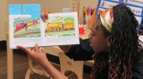 A teacher at the William L. Mallory Learning Center at Cincinnati State reads a book to young students.