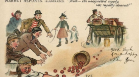 A person with a wagon filled with baskets of red apples, one brown basket of apples fell off the wagon and there are 5 people jumping on the ground to attempt and pick up the fallen apples