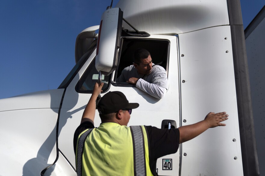 FILE - Senior instructor Markus Juarez, bottom, talks to student driver Jaime Rojas at California Truck Driving Academy in Inglewood, Calif., Wednesday, Nov. 17, 2021.