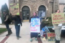Several people holding hand made signs with messages including "I need to be able to tell my kids I did not stay silent" and "Jason Buckland please don't sell" and "Preserve Monroe no data center."