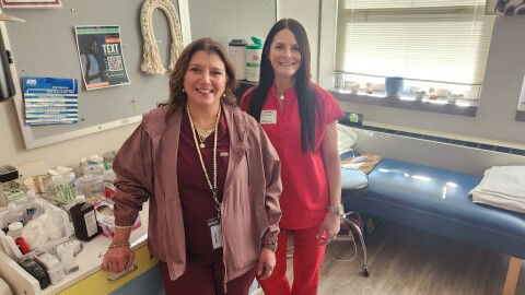 Theresa Cesarini, travel school nurse, and Cary Laboranti, coordinator of the pilot project, stand in the nurse's office at Dunmore High School. Cesarini assists with medical duties in schools throughout Lackawanna County.
