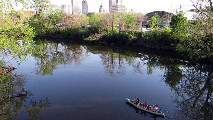 A family canoes down the St. Mary's River near downtown Fort Wayne. City officials are seeking designs for a downtown riverfront promenade.