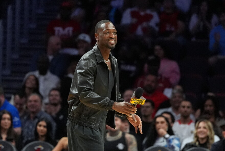 Miami Heat legend Dwyane Wade walks on the court during a time out while watching an NBA basketball game between the Miami Heat and the Dallas Mavericks, Monday, Oct. 26, 2026, in Miami.