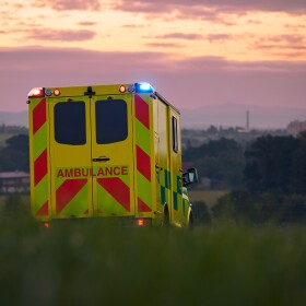 Yellow ambulance car of emergency medical service on country road. Themes rescue, urgency and health care.