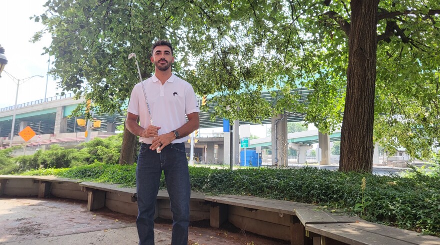 Michael Pabón at New England Public Media in Springfield, Mass., on July 18, 2023. He holds a golf club to represent the golf tournaments he hosts for the benefit of helping his organization, The GiveBack Group.