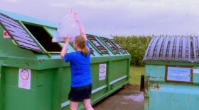 Amy Rather drops recycling into one of the bins behind the Johnson County Recycling District office. After July 31, this bin won't be available.