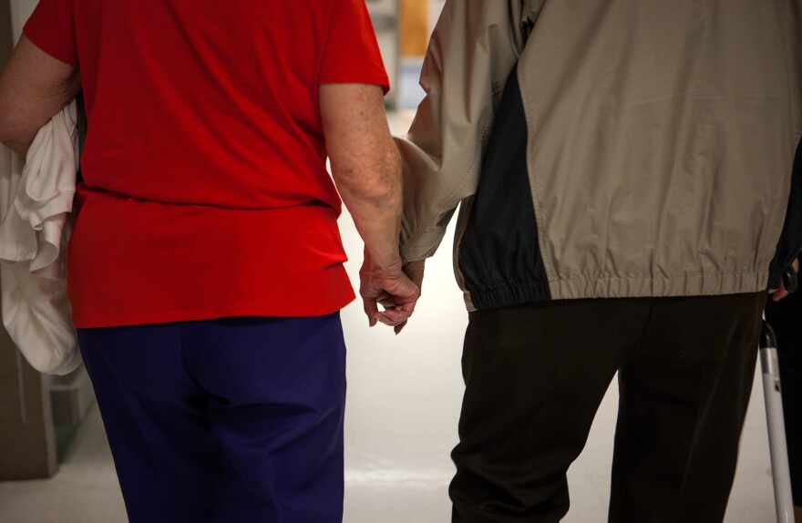 Cavell holds his wife Hilda's hand during a visit to the VA facility in Richmond, Va., in May 2015 for a series of exams to re-evaluate whether he can qualify for disability benefits after being exposed to mustard gas testing during his time in the military.