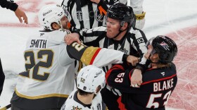 Vegas Golden Knights' Cole Smith (22) and Carolina Hurricanes' Jackson Blake (53) scuffle as an official tries to separate them during the second period of Game 5 of the NHL hockey Stanley Cup Final series in Raleigh, N.C., Thursday, June 11, 2026. (AP Photo/Ben McKeown)