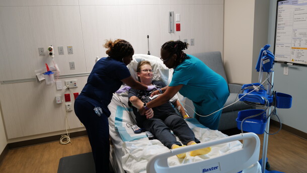 Two nurses help move a patient at Sentara Albemarle Medical Center.