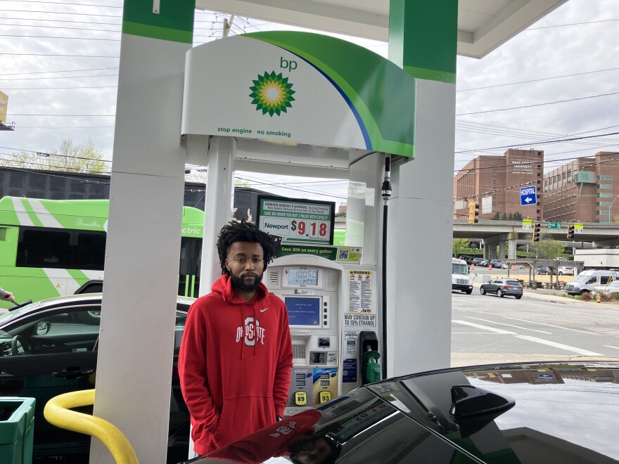 Man standing by car at gas station