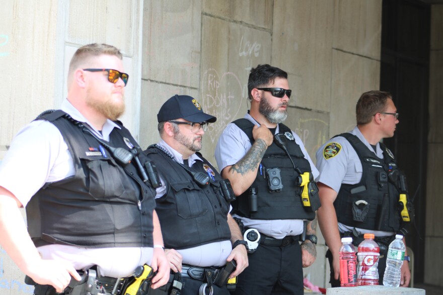 Law enforcement officers from different agencies watched as demonstrators dismantled an encampment outside local government office buildings on July 1.