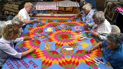 Clockwise starting in the lower left corner are: Gail D Kessler of Oley, Regina M Moyer of Shanesville, Marie R Moyer, of Shanesville, Laura K Rhoads of Oley, Eleanor A Shaner of Kutztown, and Betty D Hoch of Oley.During a Quilting Bee at the Lady Finger Studio on Oley Turnpike Road in Oley Saturday afternoon. The women at the Bee were finishing a quilt that Gail D Kessler designed and made the top for (Gail is one of the six women in the Bee, and the owner of Lady Finger).The Quilt contains pieces with signatures of people who donated money at last year's fair. The quilt will be auctioned off at this year's Oley Valley Fair, which is celebrating it's 60th anniversary.