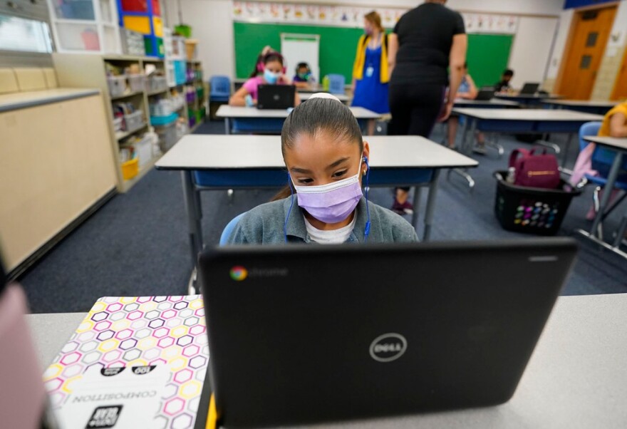 Esperanza Raimirez works on a laptop in a classroom in Newlon Elementary School early on Tuesday, Aug. 25, 2020. The school was one of 55 Discovery Link sites set up by Denver Public Schools where students participated in remote learning from a school in Denver during the pandemic.