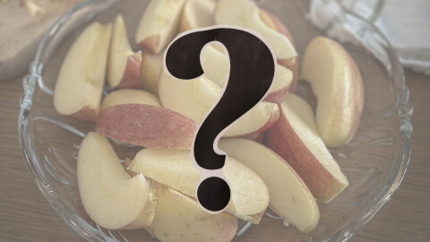 A bowl of sliced up apples; a question mark in the foreground