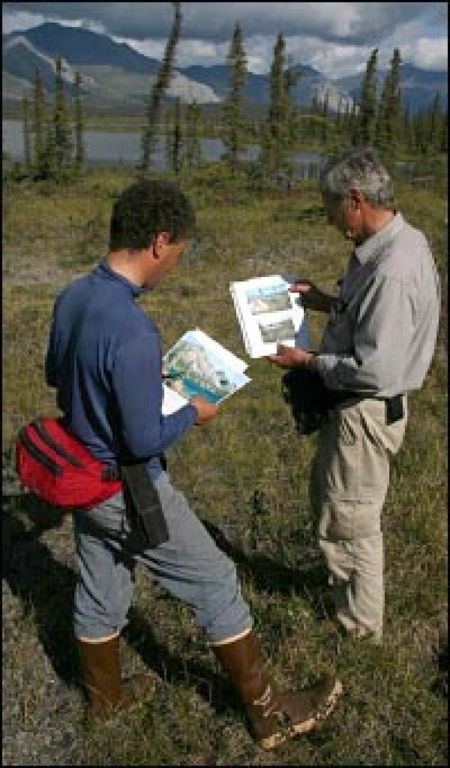 2006 expedition graduate student Martin Robards (left), and Schaller use old photos to find the campsite of the original 1956 journey.