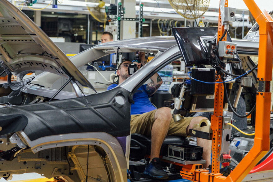 An FCA US employee uses a happy seat to install the right and left sun visors on a Jeep Cherokee at the Belvidere (Ill.) Assembly Plant. 