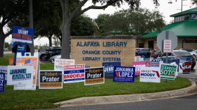 Campaign signs crowd the grass at the Alafaya Library parking lot in Orange County on Monday, Oct. 19, 2026. More voters cast ballots early in person at the library on Monday than at any other early voting location in Orange County.