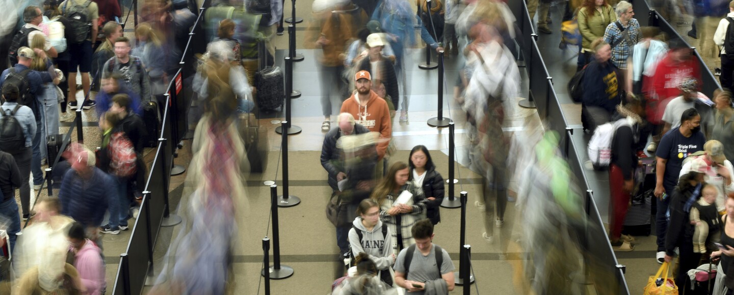 Travelers wait in a security line at Denver International Airport.