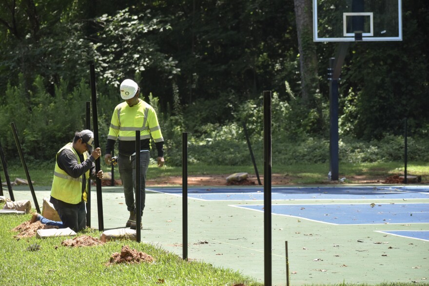 workers converting a basketball to a pickleball court