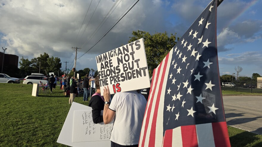 A protester carries a U.S. flag and a sign reading "Immigrants are not felons but the President is" during a protest against U.S. Immigration and Customs Enforcement in Tulsa on Wednesday, September 24, 2025.