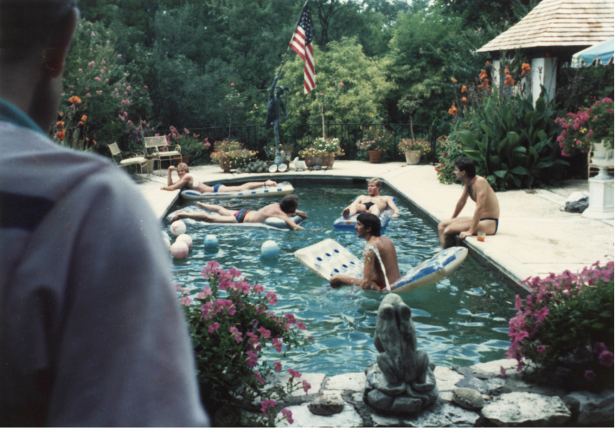 An old photograph of men in a swimming pool.