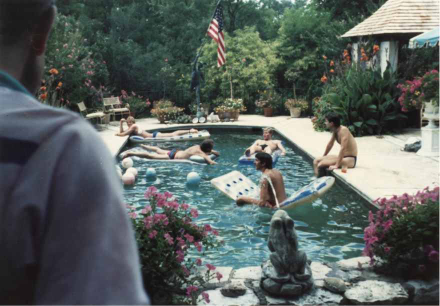 An old photograph of men in a swimming pool. 