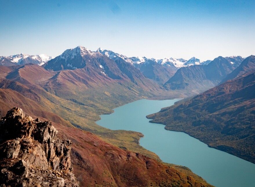 A narrow lake among snow-capped mountains