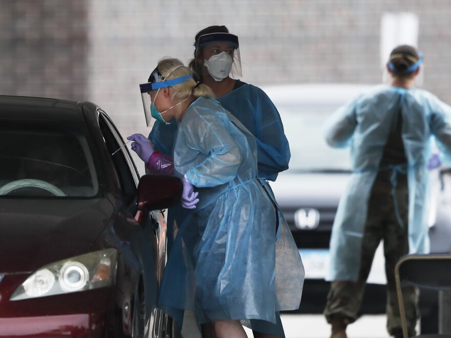 A health worker performs a coronavirus test at a Test Iowa site in Waukee, Iowa.