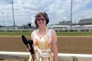 A reporter holds recording equipment trackside at Churchill Downs.