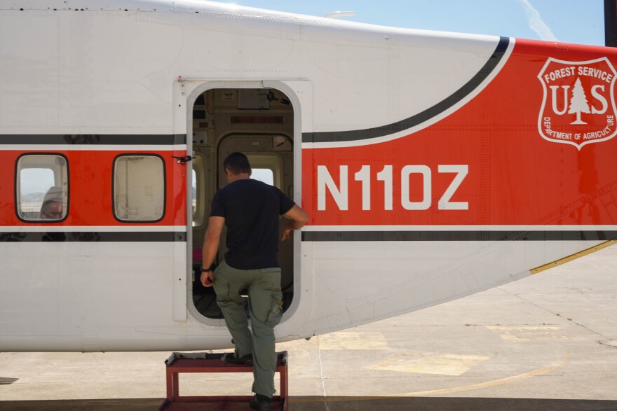 A man steps into a Forest Service airplane.