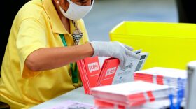 An election worker opens envelopes containing vote-by-mail ballots for the Washington state primary at King County Elections in Renton, Washington on August 3, 2020.