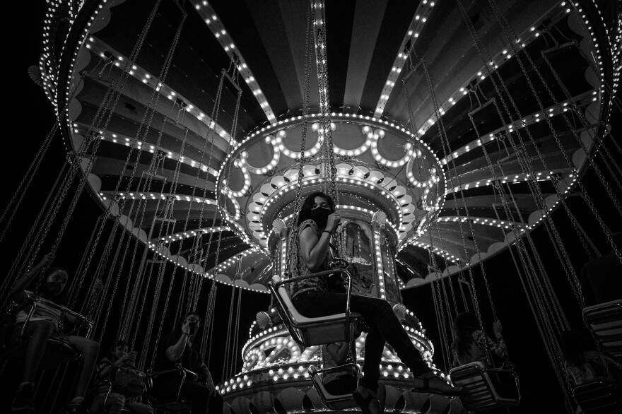 A woman wears a face mask, recommended by the World Health Organization to prevent the spread of the coronavirus, at an amusement park ride in Manaus, on Dec. 9, 2020. Health experts say the reopening of public activities at the end of 2020 helped lead to a new peak in COVID-19 infection in the largest city in the Brazilian Amazon in early 2021.