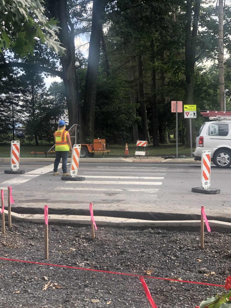 Construction workers stand at the intersection of Park Avenue and North Atherton Street.