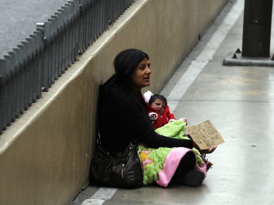 A woman begs for alms along the Las Vegas strip in Las Vegas, Nevada, on Nov. 11, 2011. U.S. unemployment edged down to 8.3 percent at the end of January. Employment levels are not equal among all demographics.