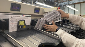 King County elections officials demonstrate one of the machines that helps sort ballots in advance of the March 10 presidential primary.