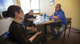 Justin Marotta, right, takes his oral mid-term exam for a suicide prevention course at the Simmons College School of Social Work. Laura Goodman, left, is role-playing as the client, as course instructor Kim O'Brien observes. (Jesse Costa/WBUR)